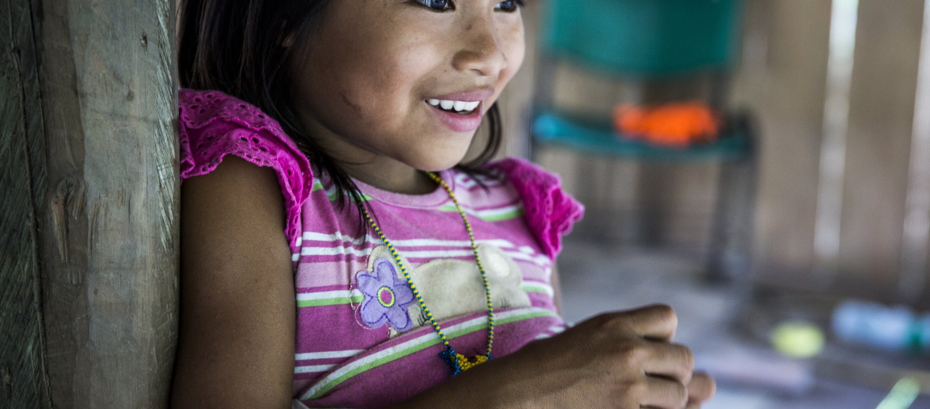 Kolumbialainen tyttö hymyilemässä, teksti lähetys- ja avustustyö.