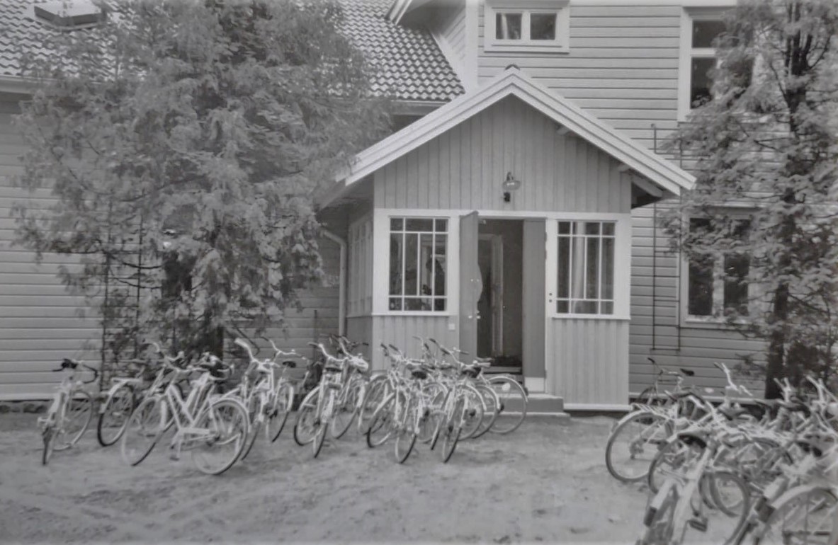 Nuorisotilan talo mustavalkoisessa kuvassa, pyöriä paljon oikeassa reunassa sekä vasemmalla keskellä.