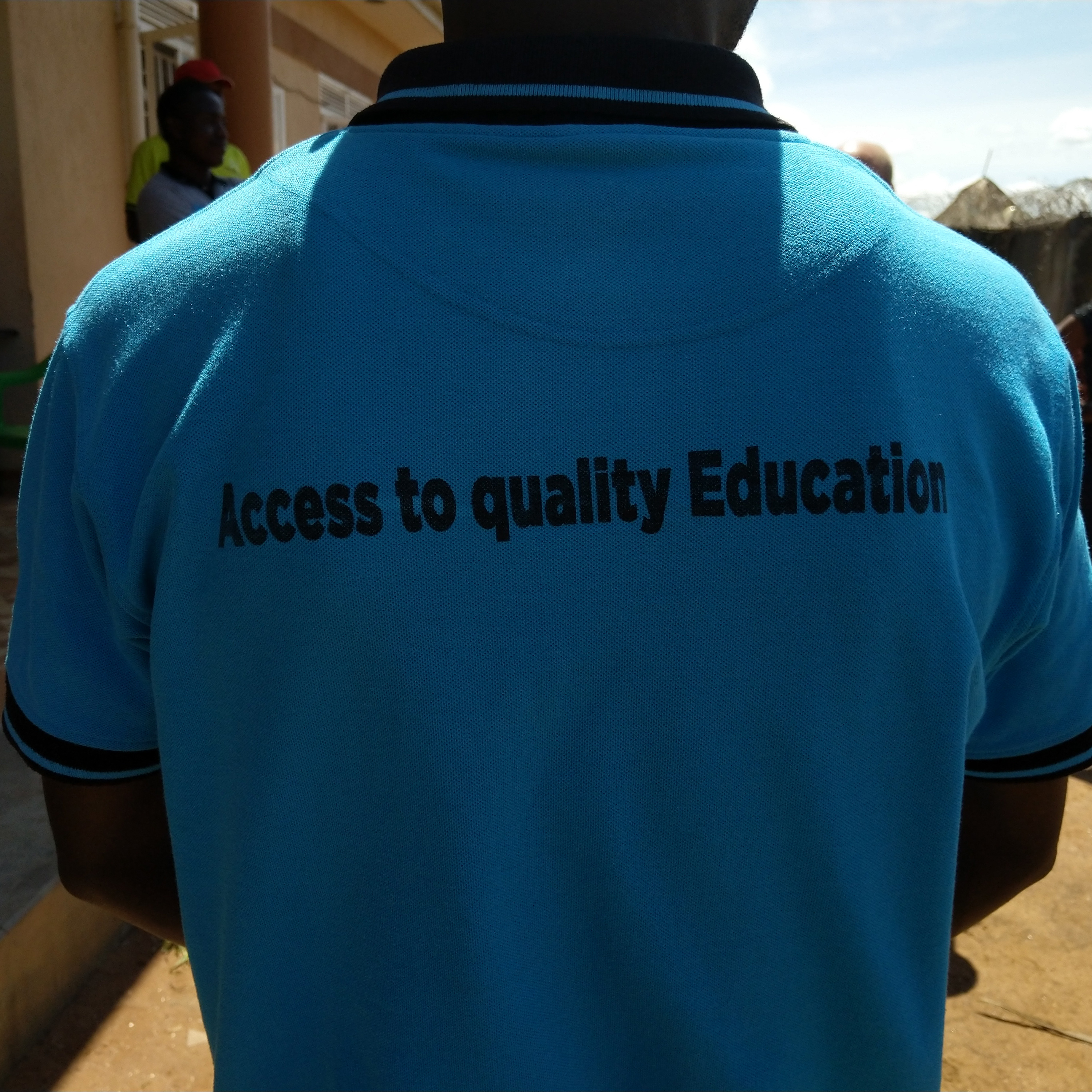 Selin mies, jonka sinisessä paidassa teksti "Access to quality Education" 