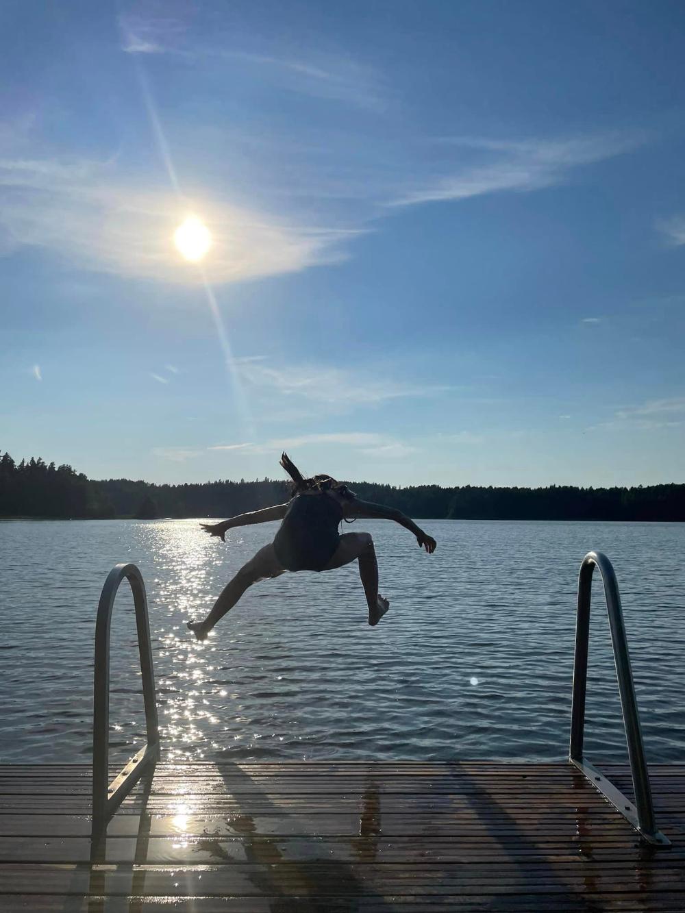 Lapsi hyppää järveen. 