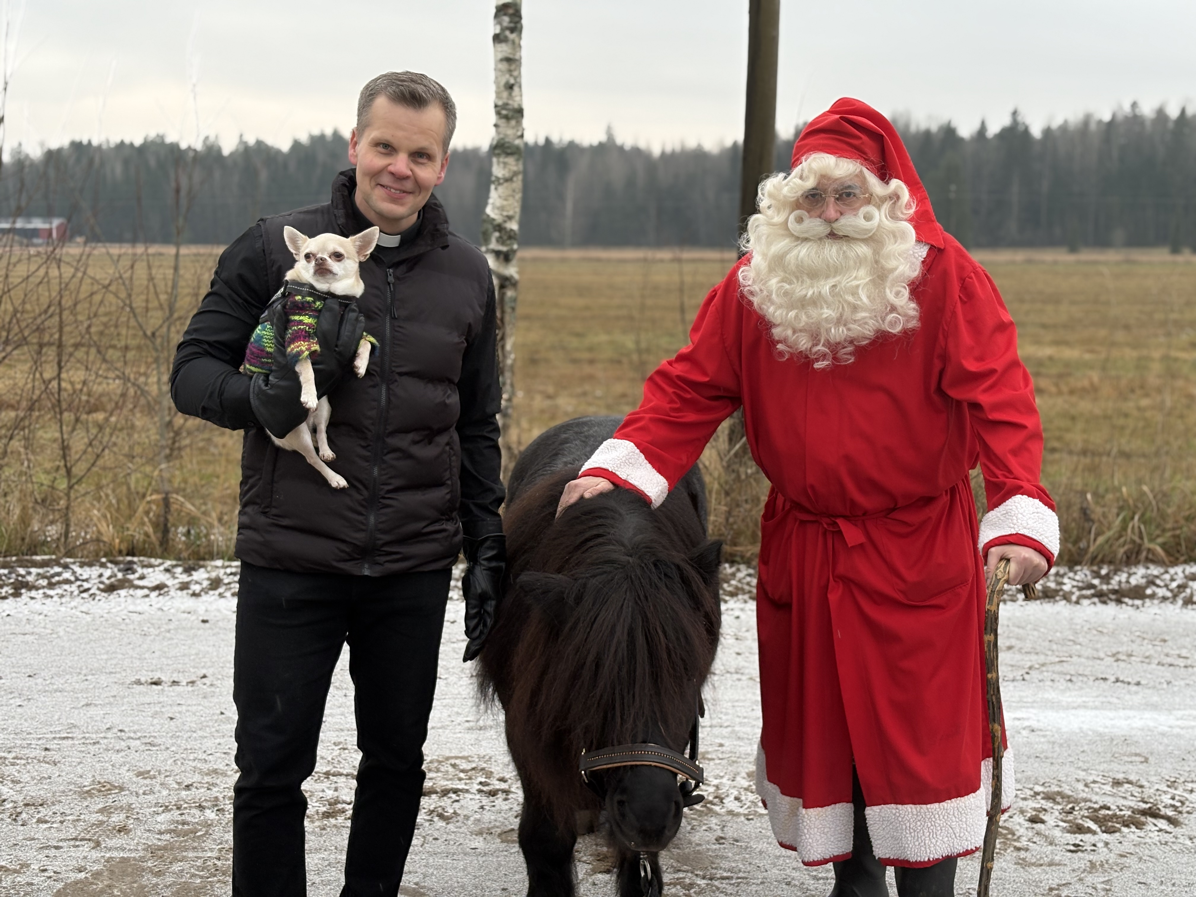 Markus Tirrasella sylissä koira, kuvassa myös poni ja joulupukki.