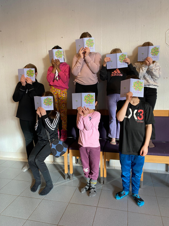 Lapsia piiloutuneena Lasten virsi -kirjojen taakse