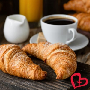 Sunnuntaibrunssi croissantteja ja kahvikuppeja sekä Yhteisvastuun sydänlogo.