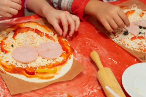 Kädet tekevät pizzaa.