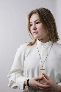 Nuori albassa pitelee puuristiä.