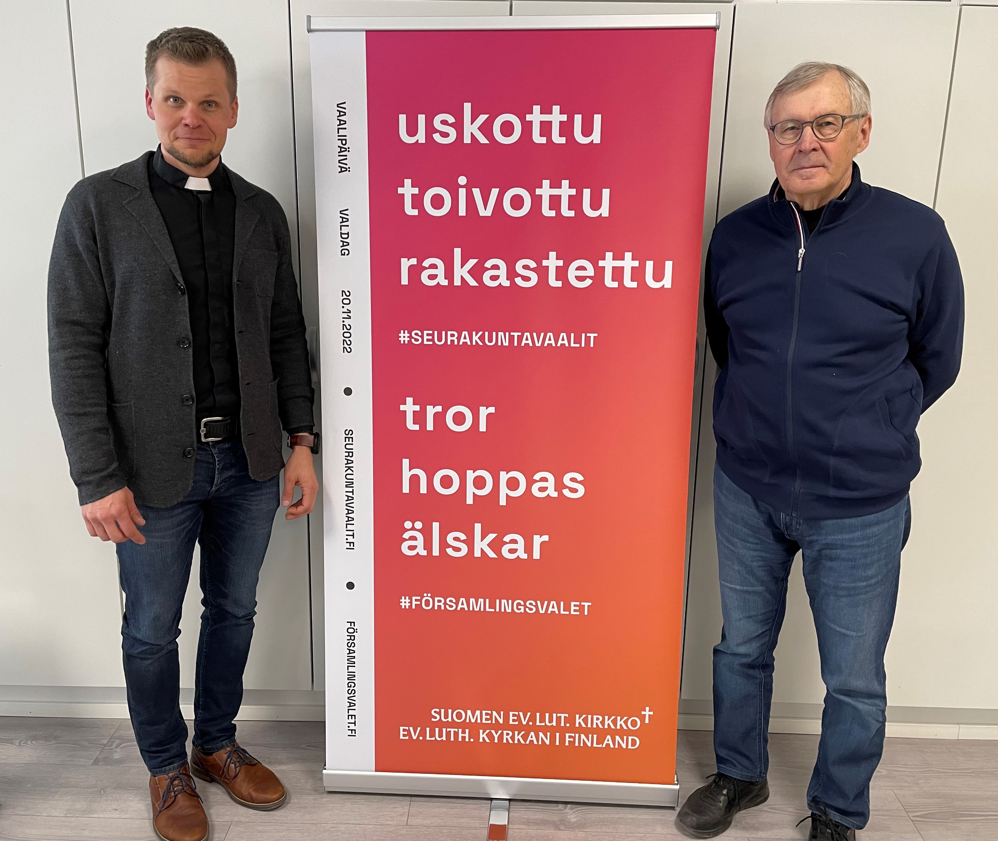 Markus Tirranen ja Risto Tyrväinen vaalien roll-upin vieressä. Roll-upissa teksti uskottu toivottu rakastet...