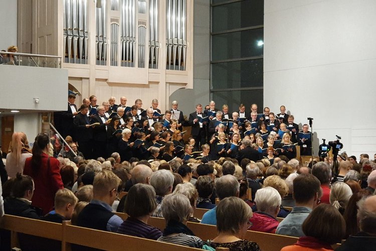 Keravan kirkko on täynnä konsertin kuulijoita. Taustalla Mozartin Requiemia laulavat kuorolaiset.